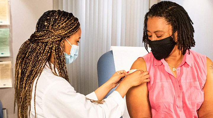 healthcare professional applying bandage to patient after a vaccine