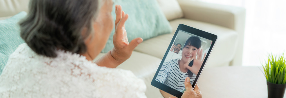 woman waving during a video chat with younger woman