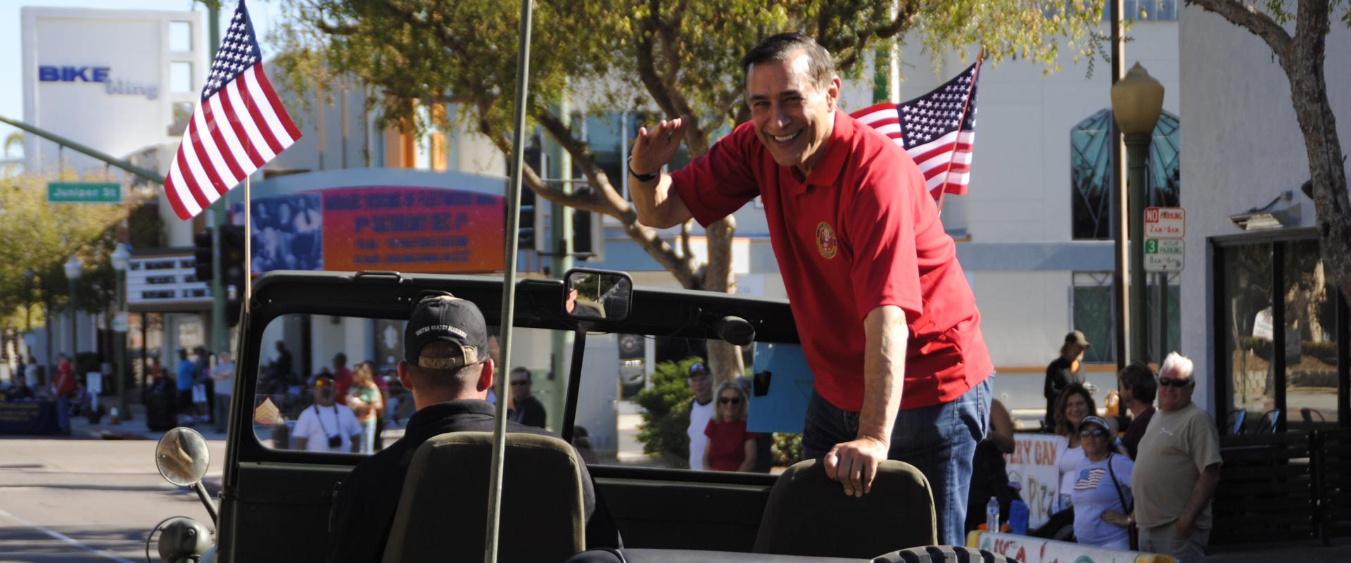 Congressman on a jeep in a parade.