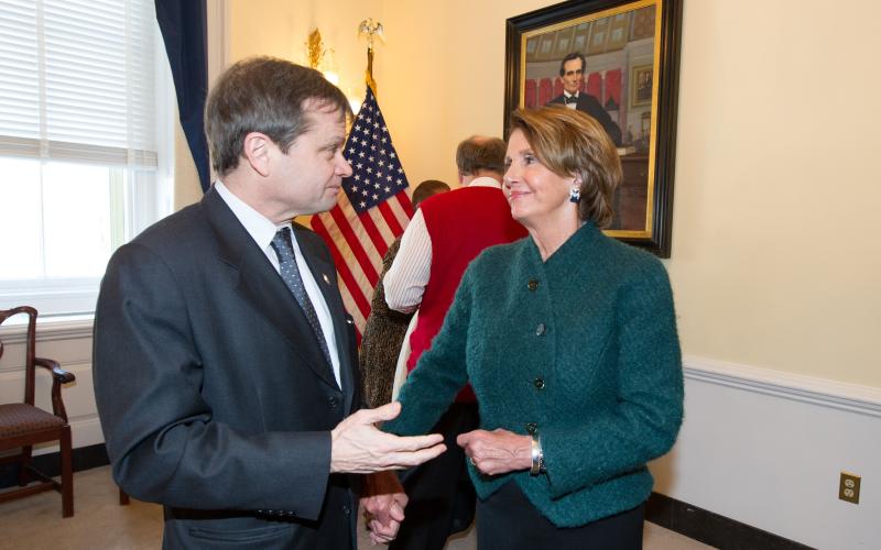 Quigley and Nancy  Pelosi speak in a Capitol Hill office with the flag and a portrait of Lincoln in the background