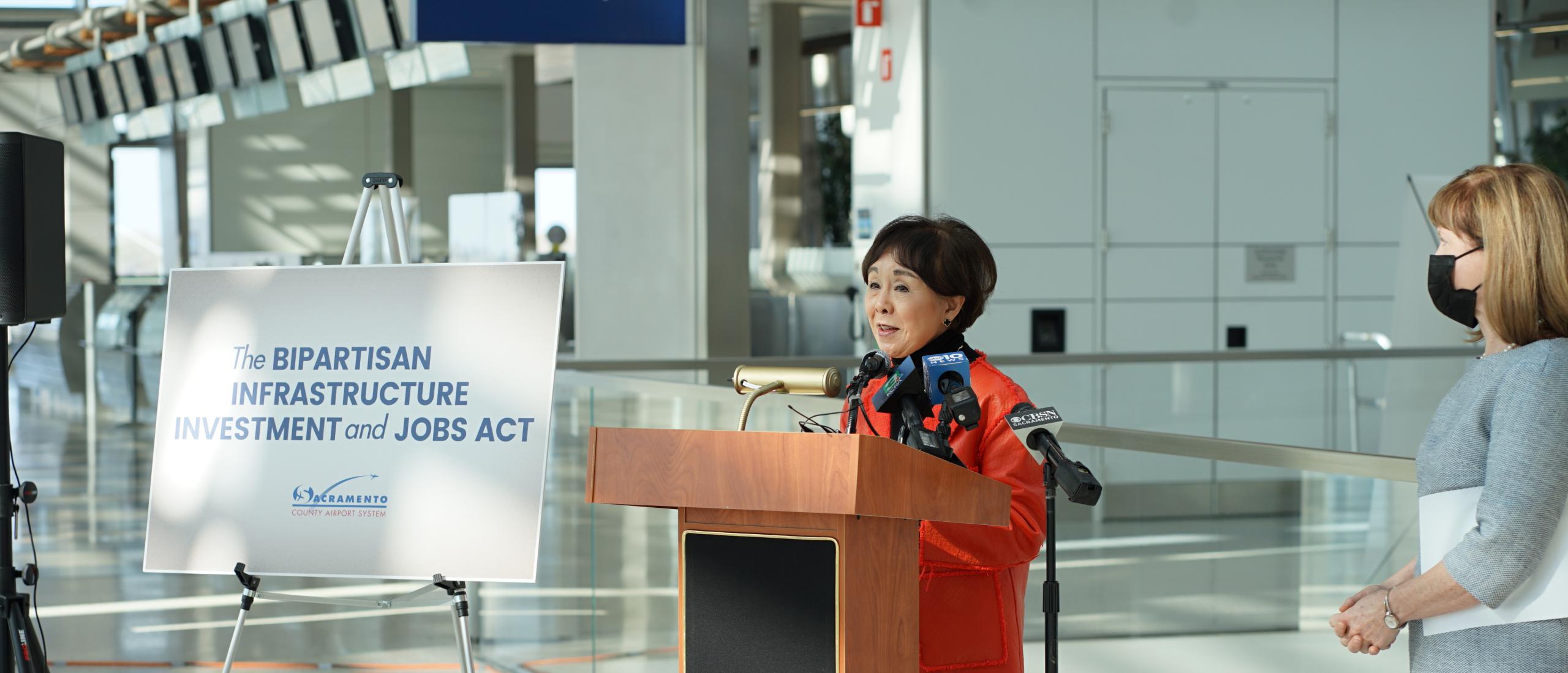 Congresswoman Matsui speaking at a podium inside of an airport.