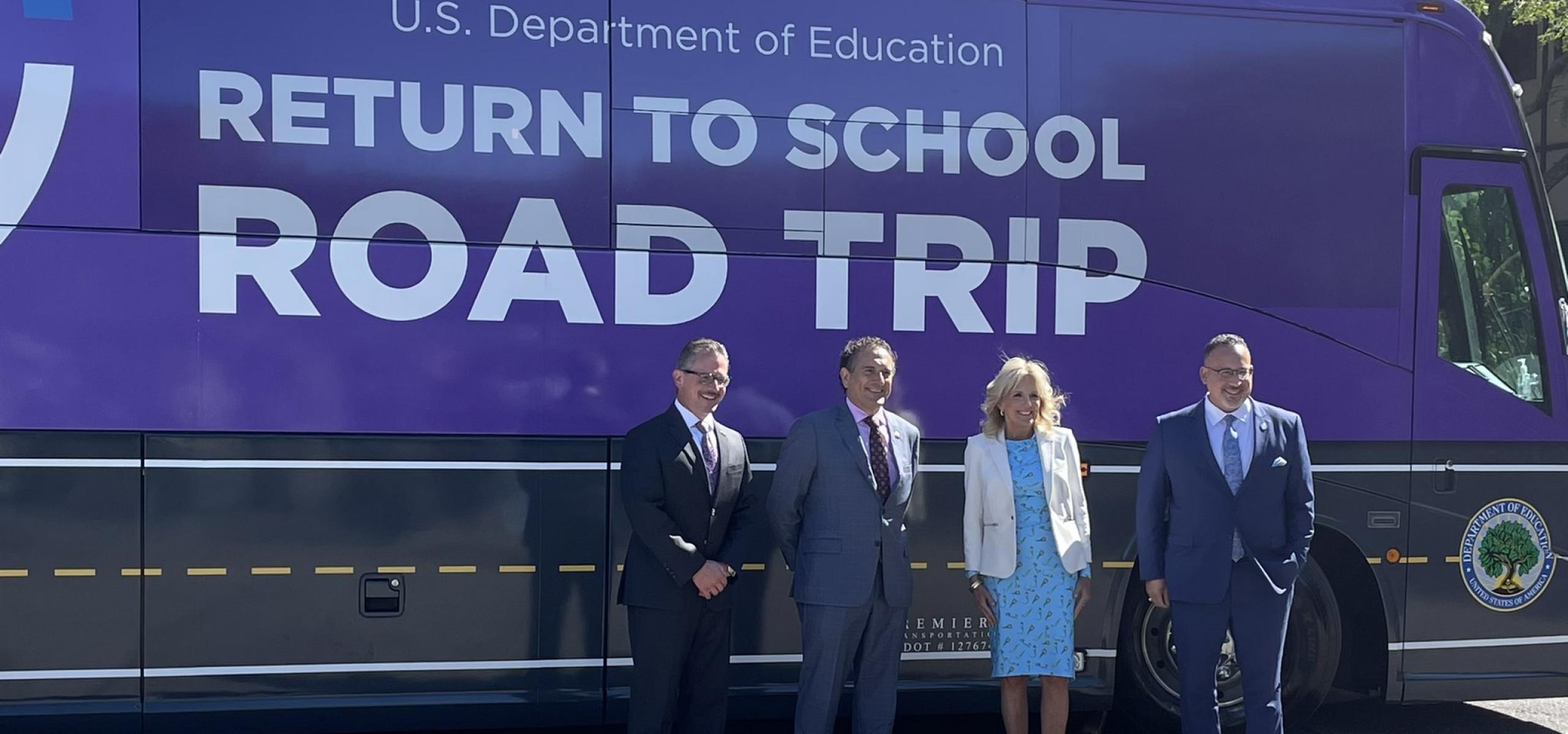 Congressman Andy Levin, First Lady Jill Biden, Secretary Miguel Cardona and Oakland County Executive Dave Coulter in front of a purple bus that reads U.S. Department of Education Return to School Road Trip