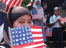 MALUSO, the Philippines -- A Filipino Muslim girl covers her face with an American flag here.  U.S. officials, including U.S. Ambassador Francis Ricciardone, visited the former al Qaeda-linked Abu Sayyaf stronghold province to oversee developmental projects funded by the U.S. government.  (Reuters photo)