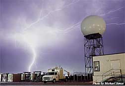 The NSSL research polarimetric radar is illuminated by night time lightning.