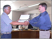 Lummi Nation Vice Chairman Willie Jones receives the country's first Standard State Plan compliance certificate from FEMA Regional Director John Pennington. FEMA News Photo/Mike Howard