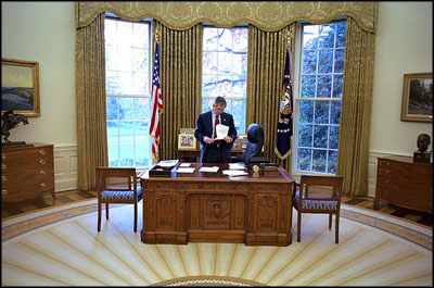 President George W. Bush reviews documents at his desk in the Oval Office Dec. 2, 2002.