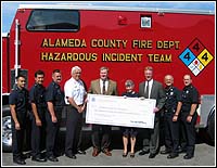 Photo of FEMA Region IX Director and the Alameda County Fire Department holding a check.