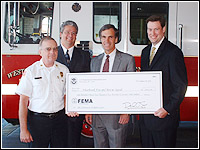 Photo of Craig, Littlefield, Violette and Allen holding FEMA check.