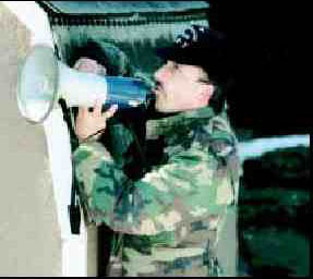 Photograph of Law Enforcement Officer speaking into a megaphone