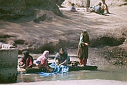 Photo of women at Nasirbagh Refugee Camp washing clothes.