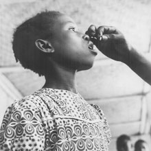 A student at the Government school in Kakata, Liberia receives a malaria pill in Liberia, 1950s.