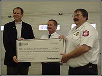 Photo of Director Hainje, Chief Loyd and Chief Massey holding a check.