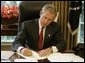 President George W. Bush signs executive orders and directives Friday, August 27, 2004, in the Oval Office, that strengthen the intelligence capabilities of the United States and take action consistent with certain recommendations of the 9/11 Commission. White House photo by Paul Morse.