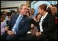 President George W. Bush and accounting clerk Neomi Gonzalez react on stage during a conversation on the economy with employees at Nu-Air Manufacturing Company in Tampa, Florida, Monday, Feb. 16, 2004. White House photo by Eric Draper.