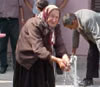 An elderly woman enjoys the water supply