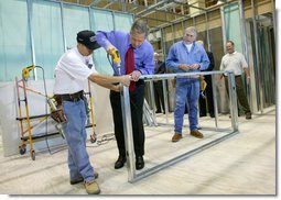 President George W. Bush uses a drill to connect a metal wall frame during a tour of the Carpenters Training Center in Phoenix, Ariz., Friday, March 26, 2004.  White House photo by Eric Draper.