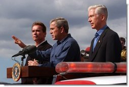 President George W. Bush stands with California Governor-elect Arnold Schwarzenegger, left, and California Governor Gray Davis as he addresses firefighters in El Cajon, Calif., Tuesday, Nov. 4, 2003. White House photo by Eric Draper.